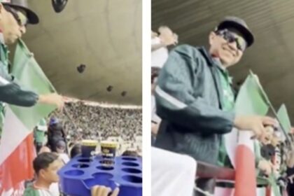 aficionado mexicano roba un trago de cerveza con su popote Aficionado mexicano roba un trago de cerveza con su popote de bandera